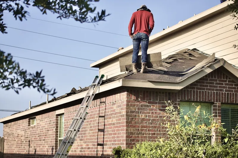 Professional roofer working on a residential roof in Spring Village